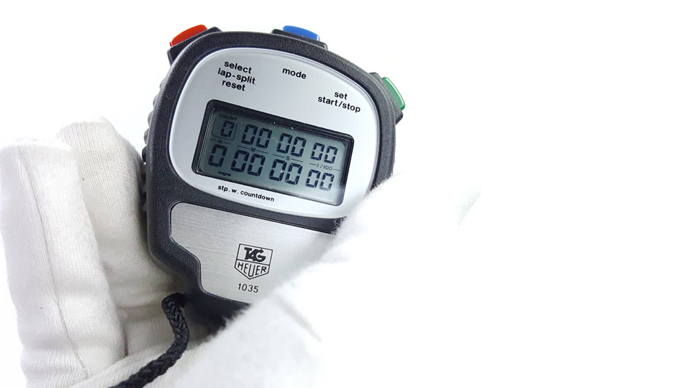 Chronomètre vintage Tag HEUER ref. 1035-microsplit --- plan rapproché avec main --- ikonicstopwatch.com