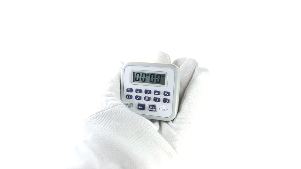 Vintage HEUER stopwatch ref. 750 - microsplit lab timer --- hand held close-up shot --- ikonicstopwatch.com
