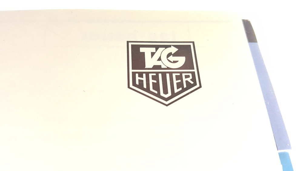 Catalogue vintage Tag HEUER 1990 --- plan rapproché logo --- ikonicstopwatch.com